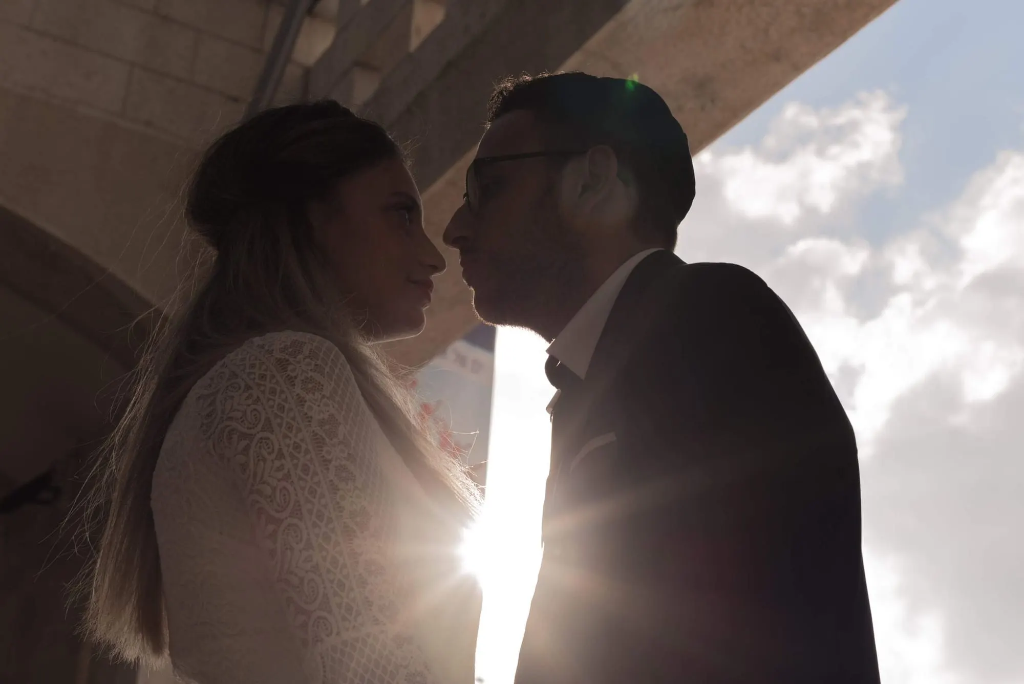 צלליות זוג מתנשק מול השמש השוקעת