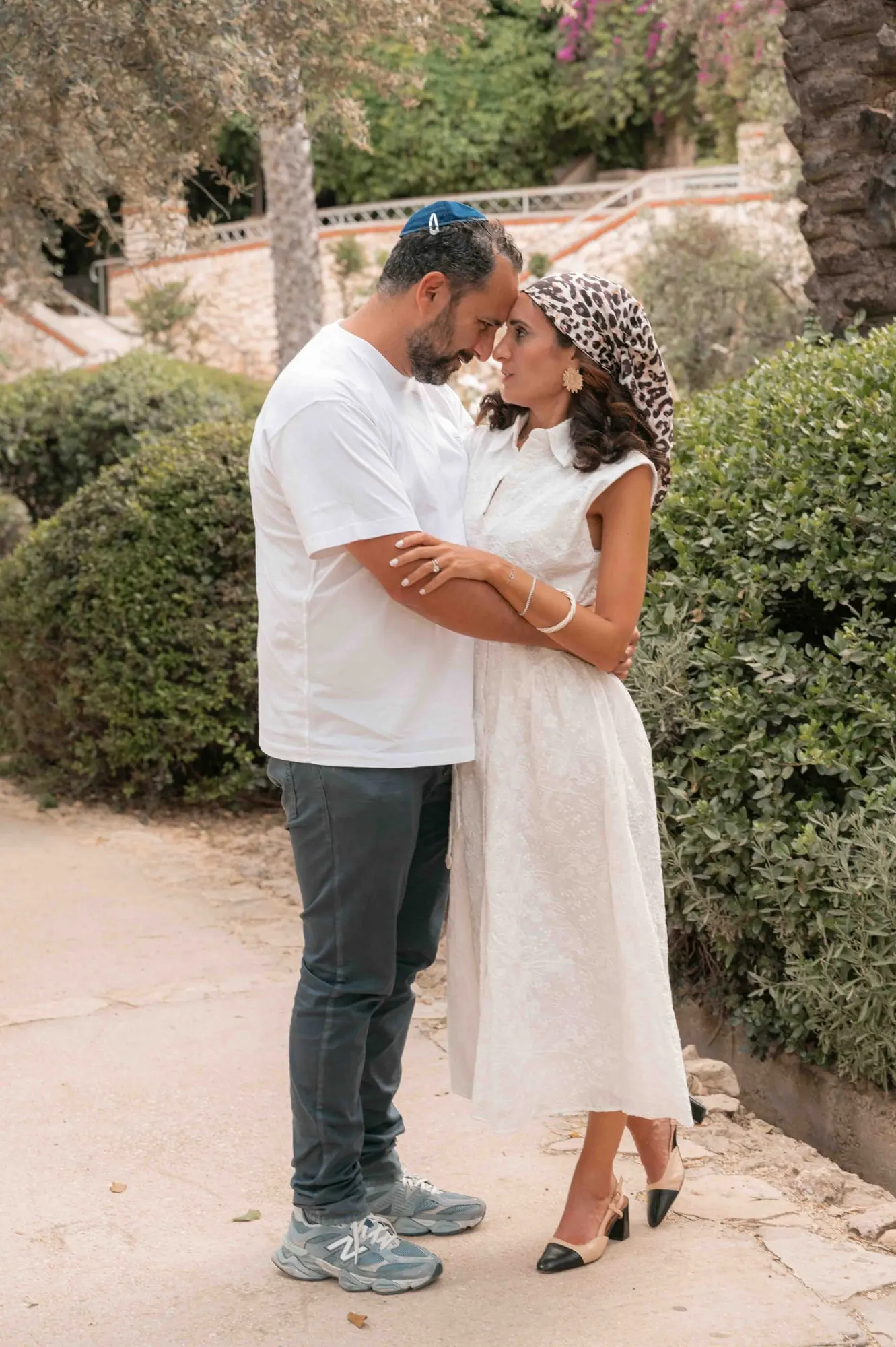 רגע של רוך בין בני זוג בגינה של אבן ירושלמית