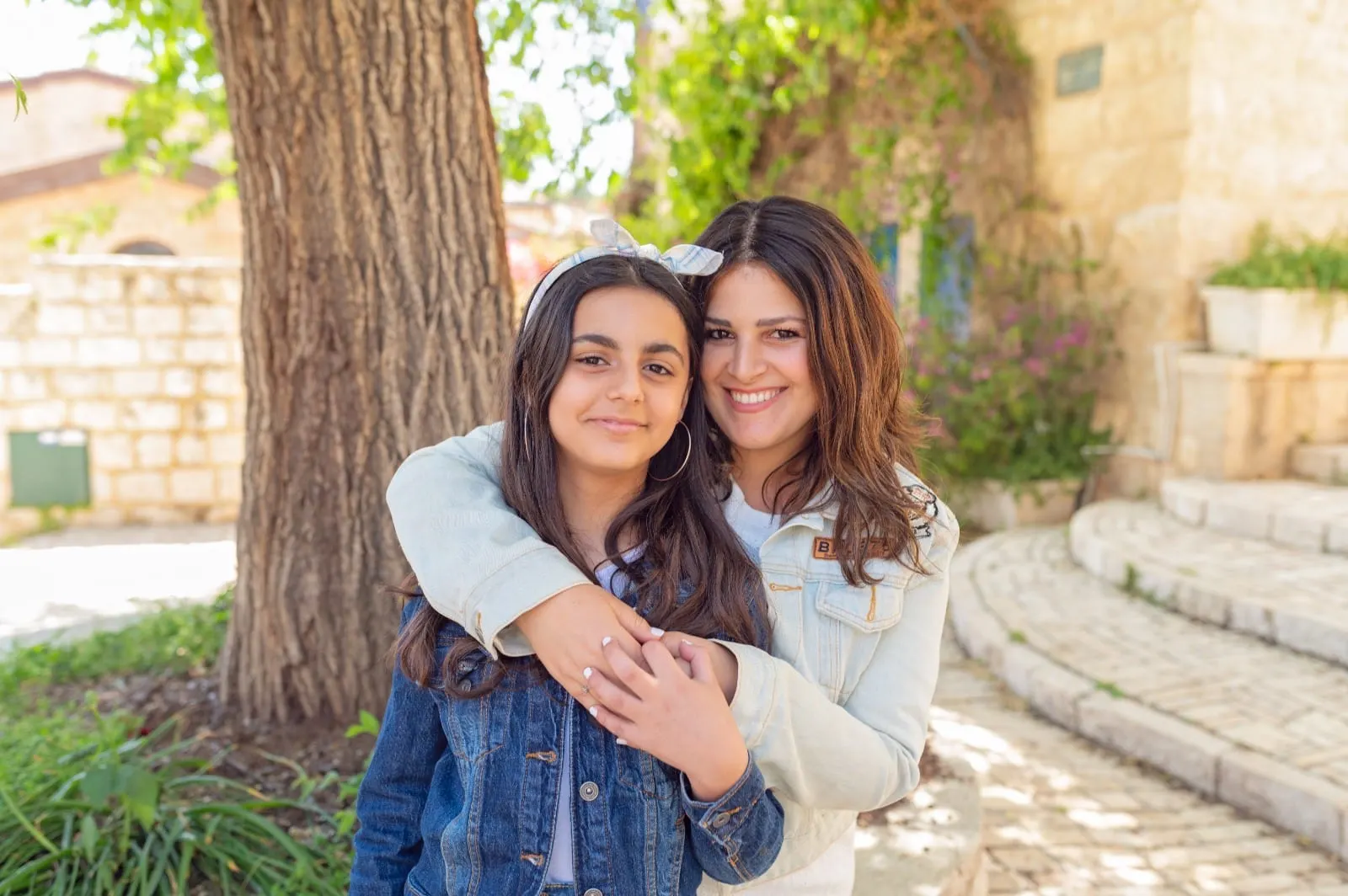 אמא ובתה מחובקות מתחת לעץ