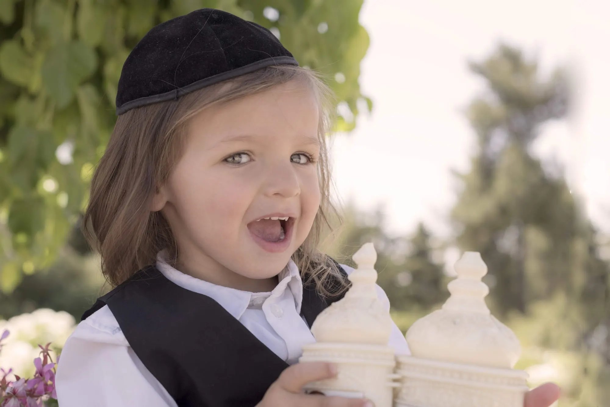 ילד עם כיפה שחורה אוחז בכתר תורה